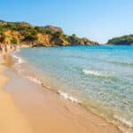 Vue panoramique de la plage de sable doré et des eaux turquoise à La Ciotat sous un ciel bleu dégagé.